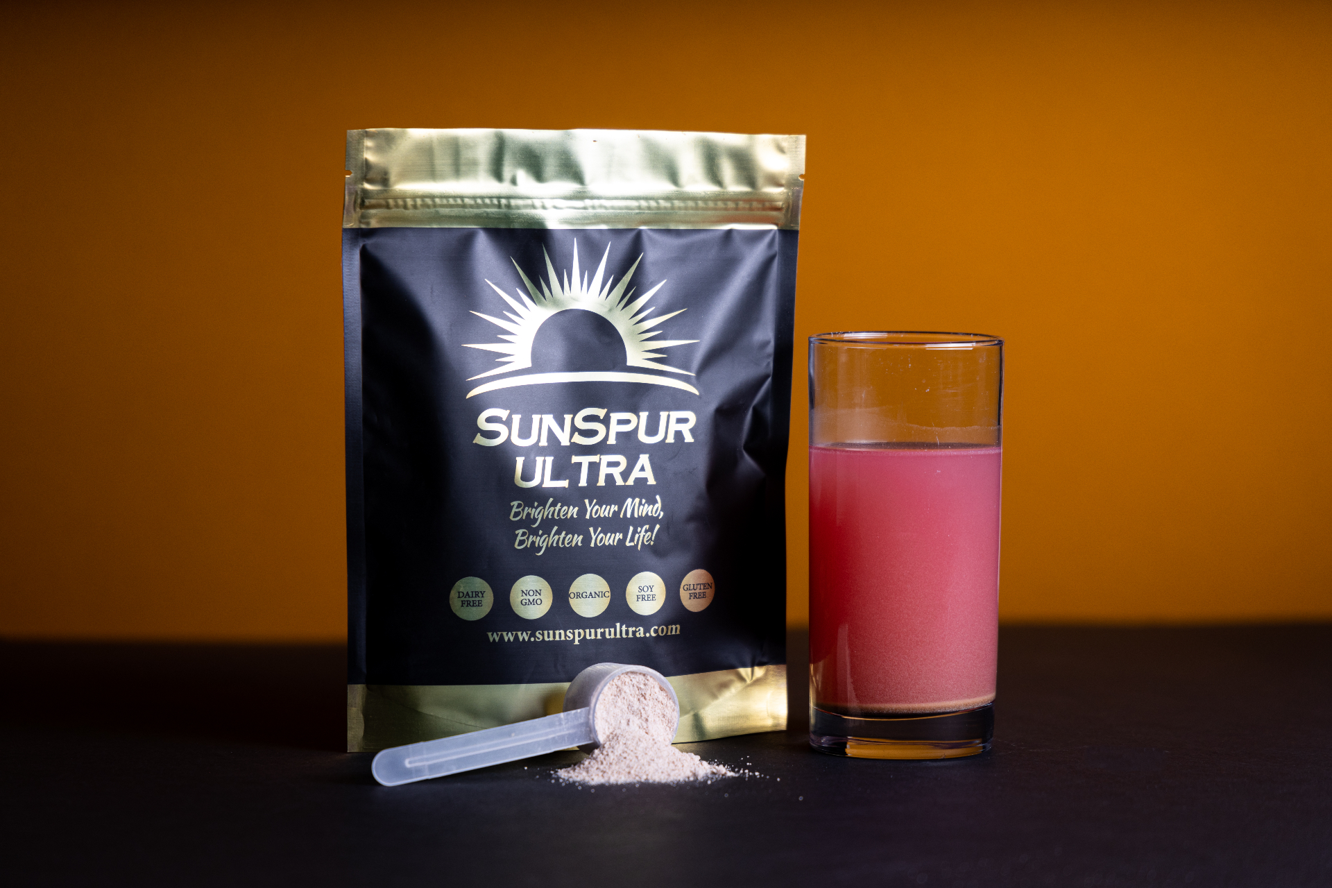 SunSpur ULTRA Life Enhancement Drink — pouch with scoop of powder and glass of prepared fruit berry drink